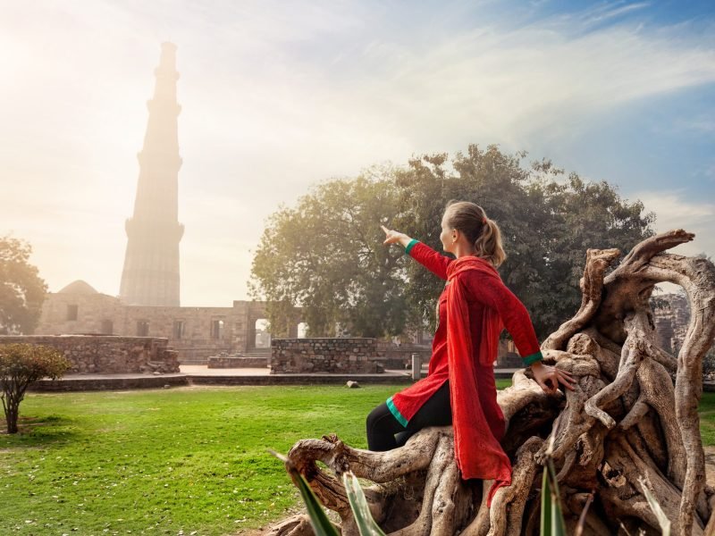 woman-pointing-qutub-minar-min